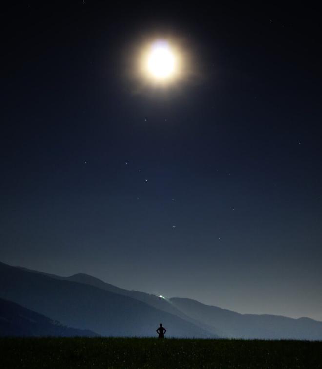 A man contemplating, staring at the night sky